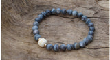black mother of pearl beads with a hand carved bone bead accented with two 14kt yellow gold beads. Made in the great Pacific Northwest by jewelry designer and artist Heather Johnson